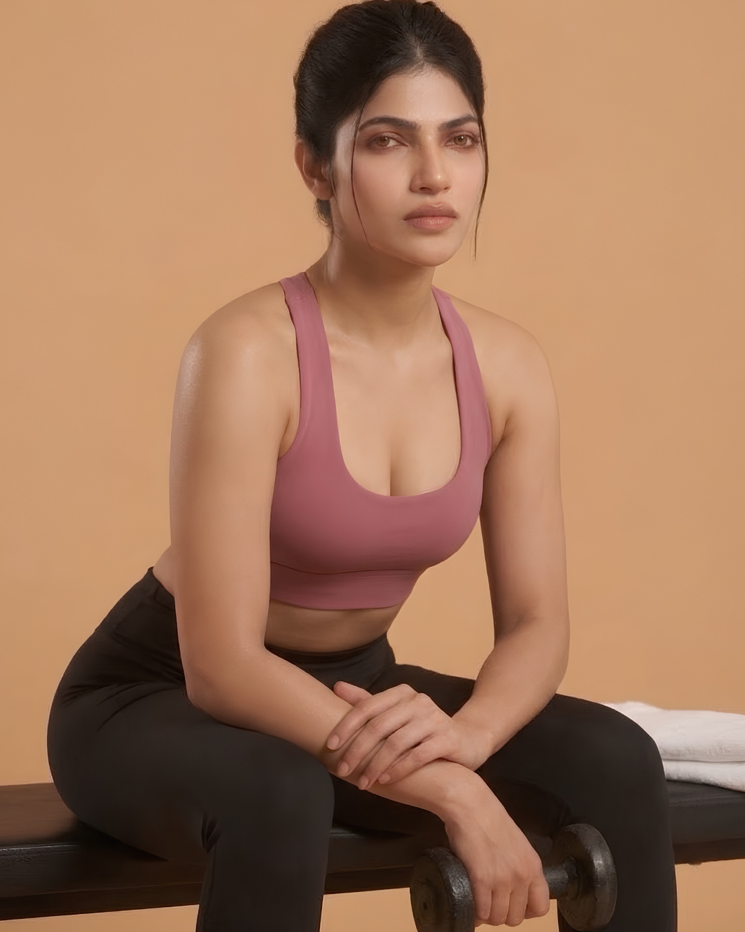 Power Sculpt Sports Bra in Pink, worn by a model seated with a dumbbell, SHAPE Lingerie